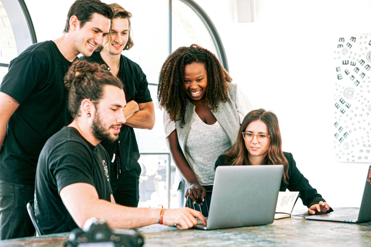 A group of people watching a laptop