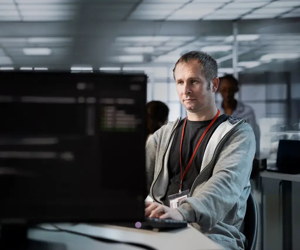 Engineer working at dual monitors in modern office, supporting media knowledge discovery with AI tools.