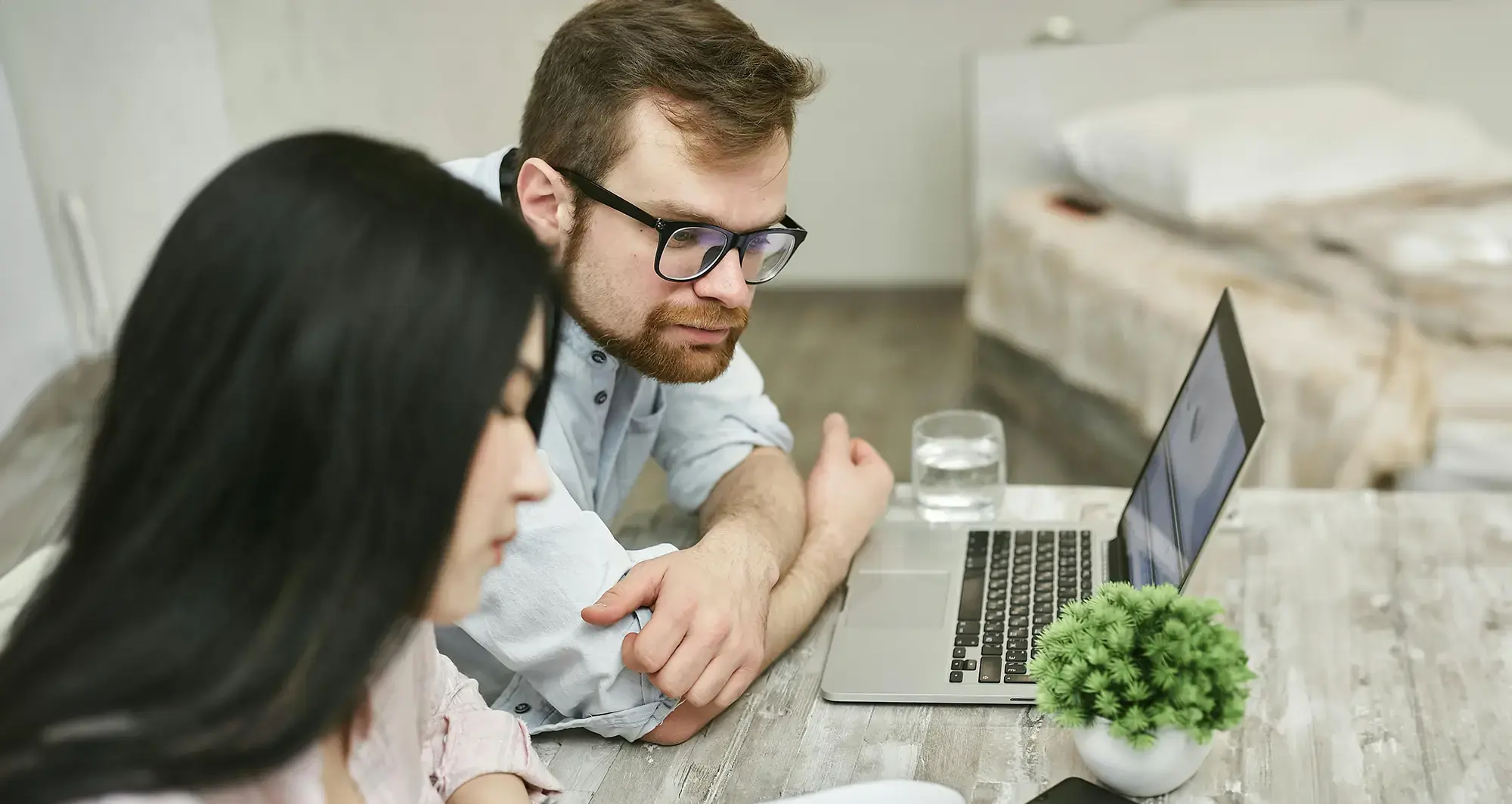 man-looking-at-womans-laptop-fullscreen-hero-desktop