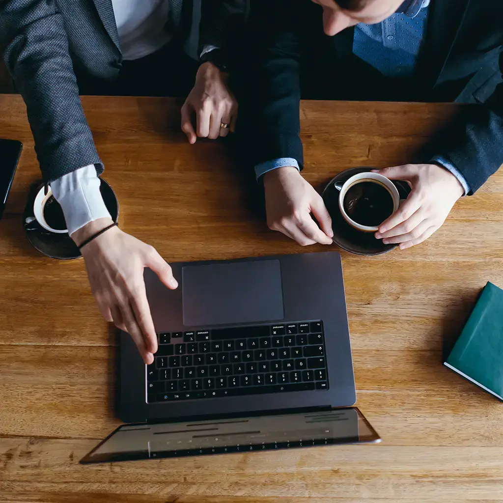 Team collaborating in a modern office lounge with laptops and notebooks.