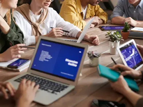 Many people sitting around a table having a meeting