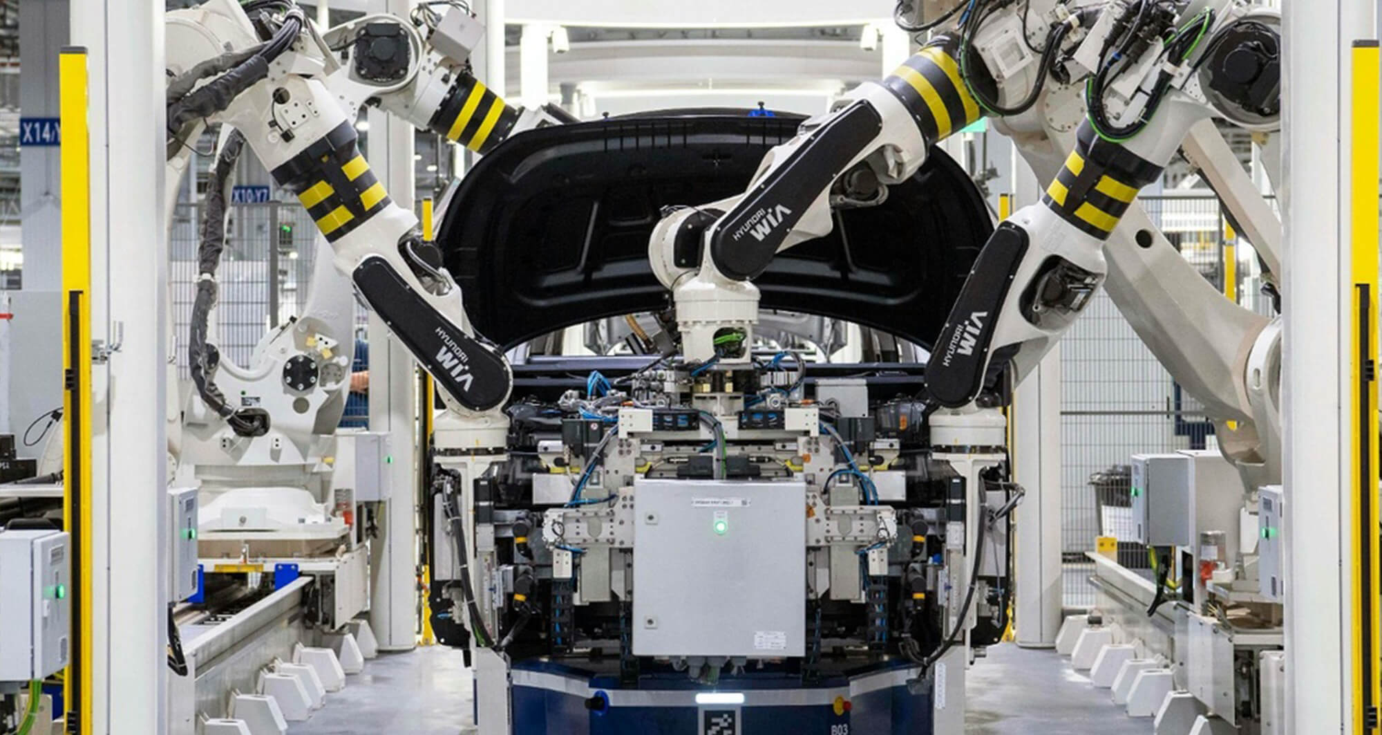 Robotic arms assembling a vehicle on an automated automotive production line