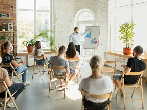 male speaker giving presentation in front of group
