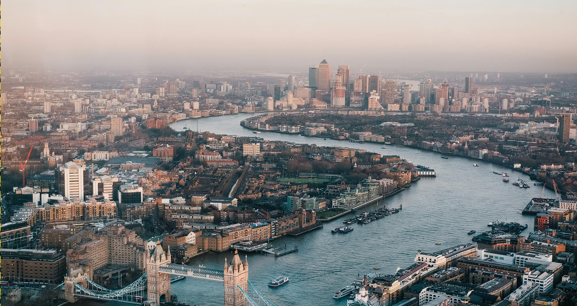 Aerial view of London skyline with Tower Bridge and Canary Wharf, symbolizing financial and technology hubs
