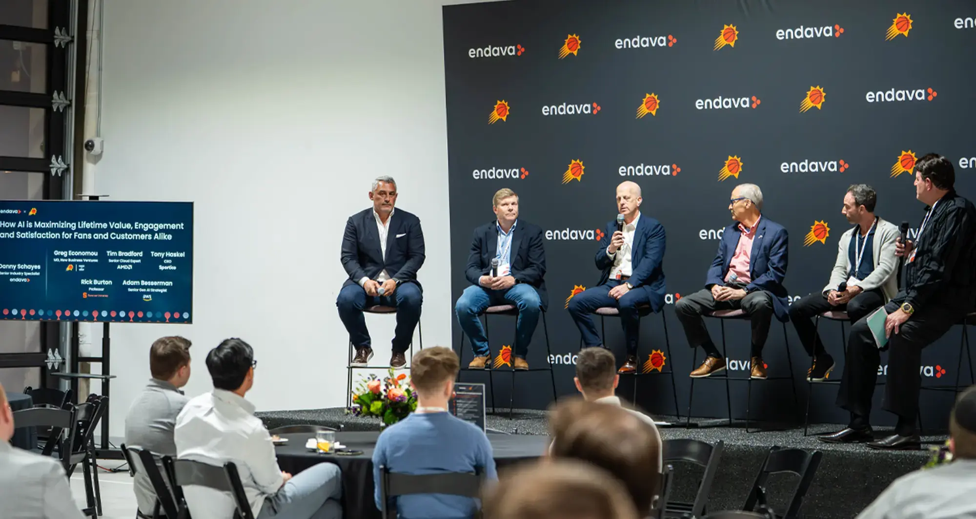 Panel of speakers discussing at an Endava and Phoenix Suns event, with attendees seated and a branded backdrop behind the stage.