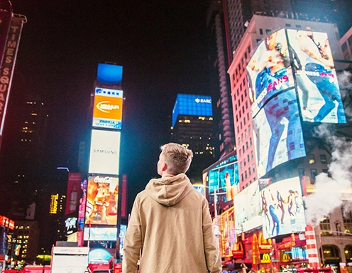 man standing in times square looking at advertisements using data and AI