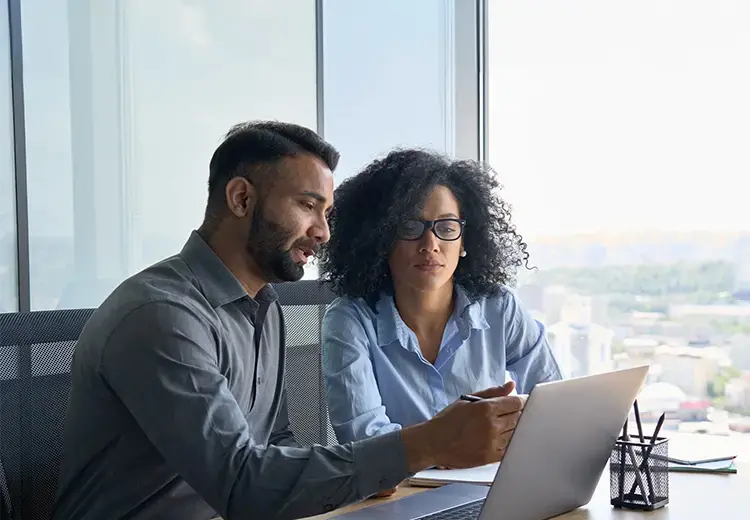 two-coworkers-looking-at-laptop-card