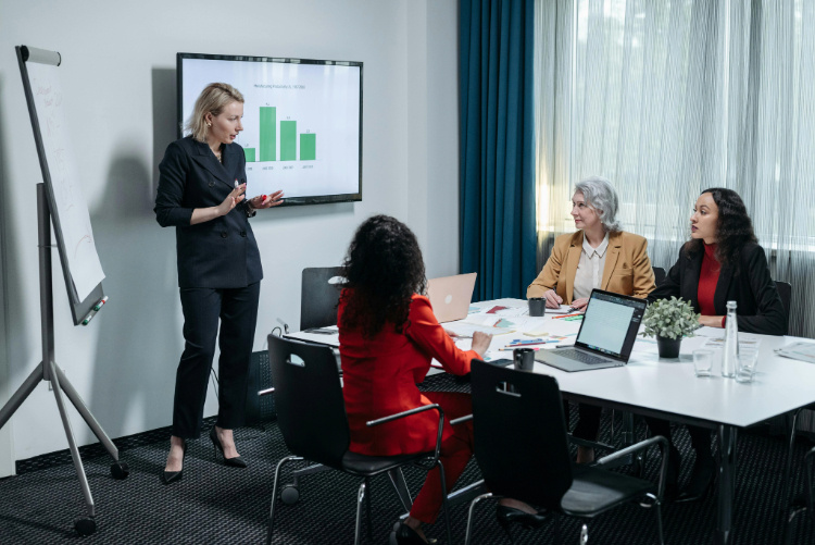 Woman giving presentation in front of electronic screen in boardroom