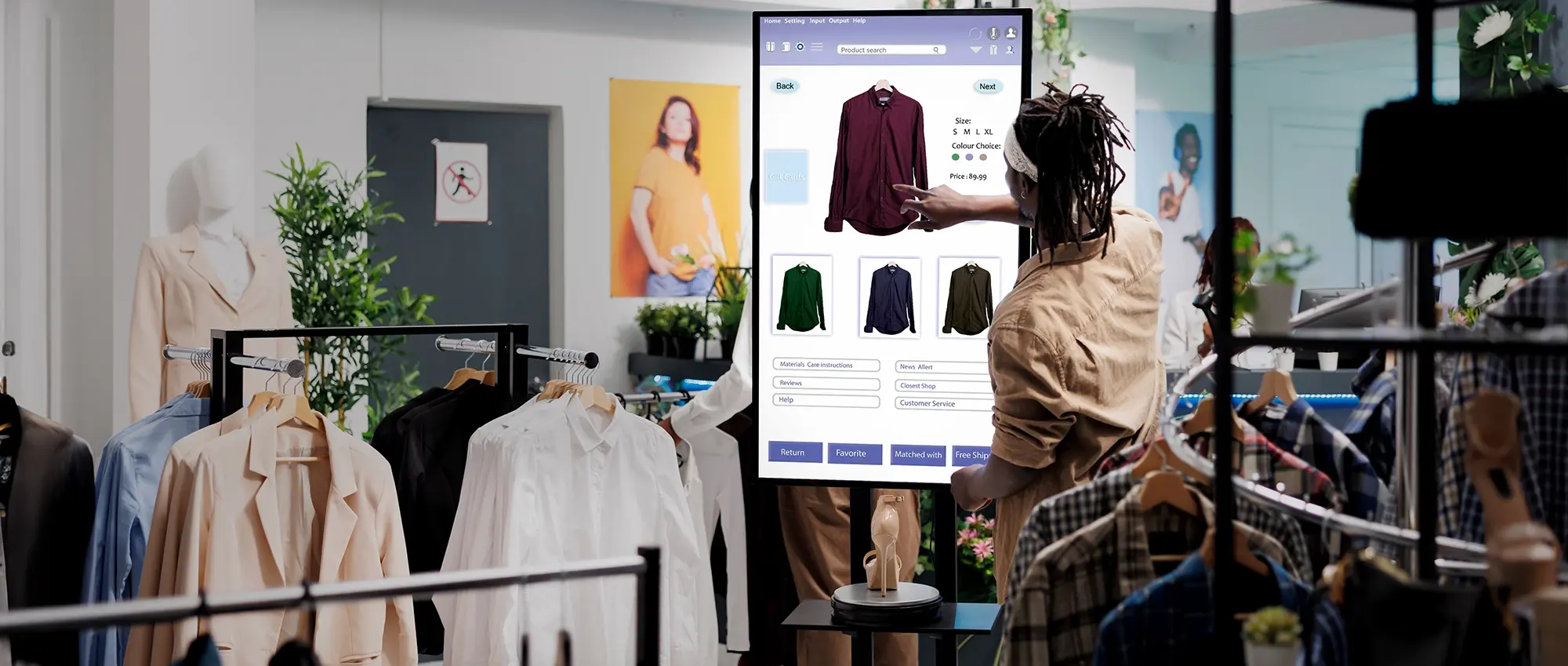 A man browsing a clothing options on a digital screen.