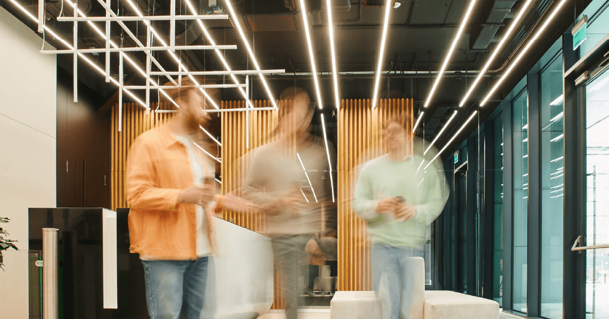 blurred image of 3 coworkers walking in motion down a hallway