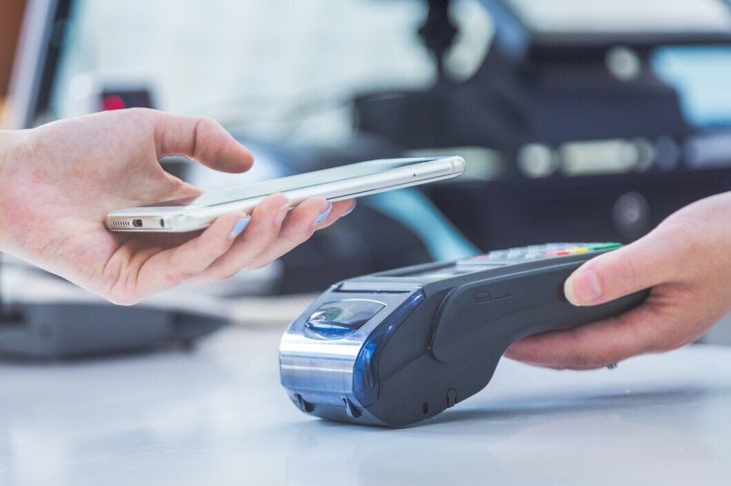 person holding phone to pay digitally at business