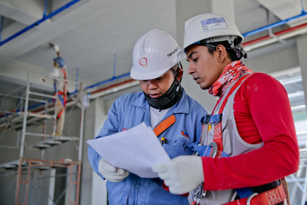 Two construction workers reviewing a paper (1)